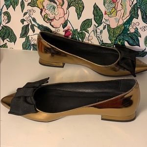 Gold Anthropologie flats with black bow
